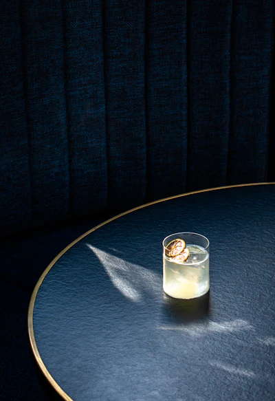 clear drinking glass with white liquid on blue round table