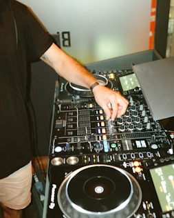 person in black t-shirt playing dj mixer