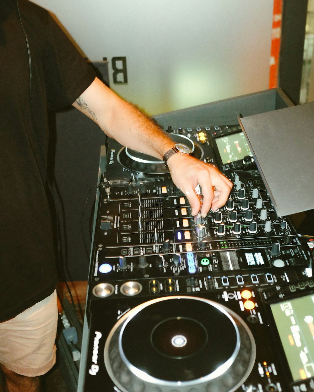 Persona in T-shirt nera che gioca DJ mixer