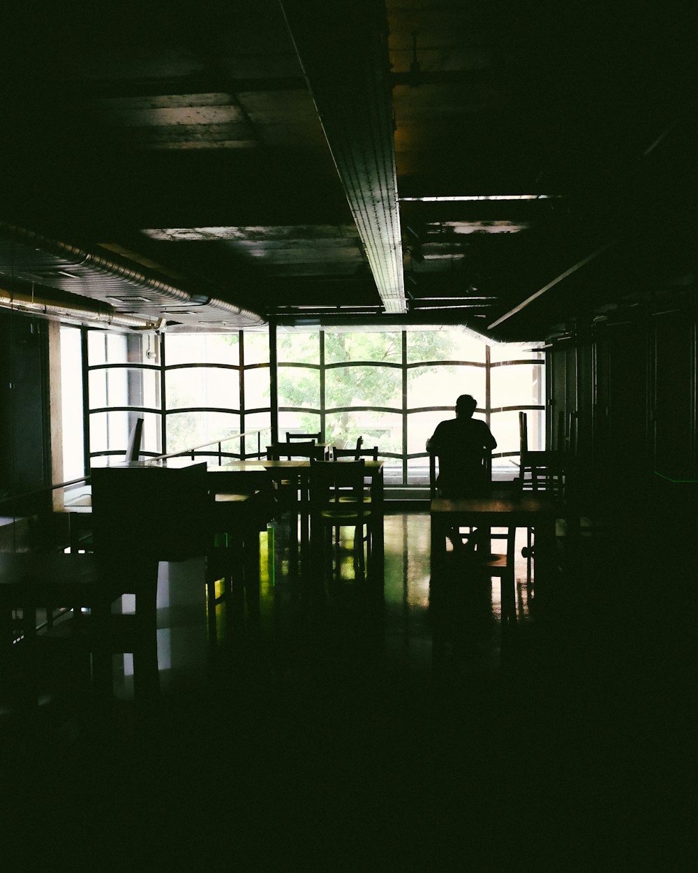 silhouette of person sitting on chair inside building