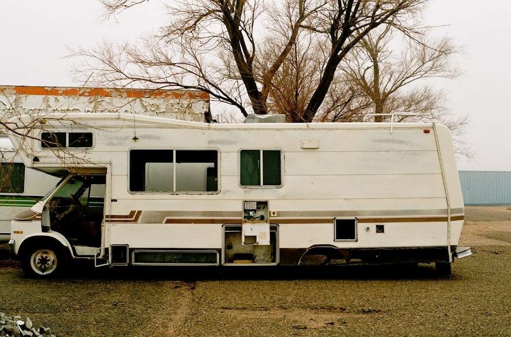 white and brown rv trailer on brown grass field during daytime