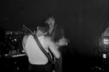 Musical artists collaborating on stage, sharing passion and creativity.