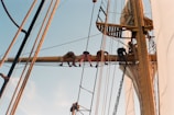 Crew members coordinating ship maintenance on deck under clear skies.