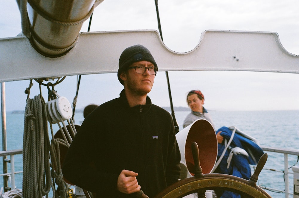 man in black dress shirt standing on boat during daytime