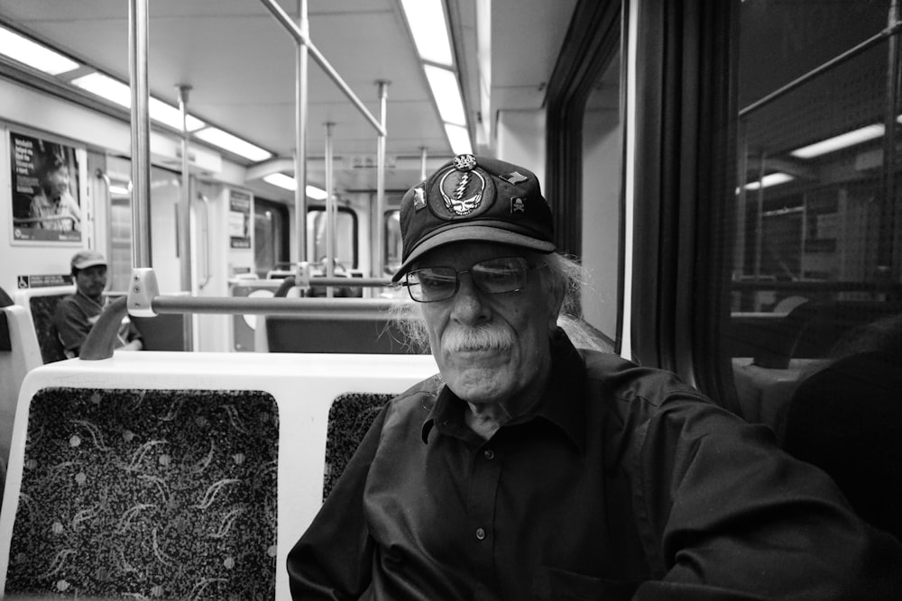 grayscale photo of man wearing black jacket and cap