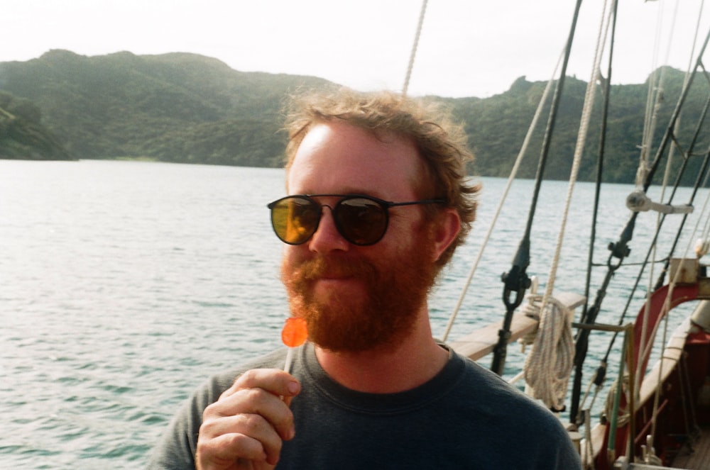 Homme en chemise noire à col rond portant des lunettes de soleil