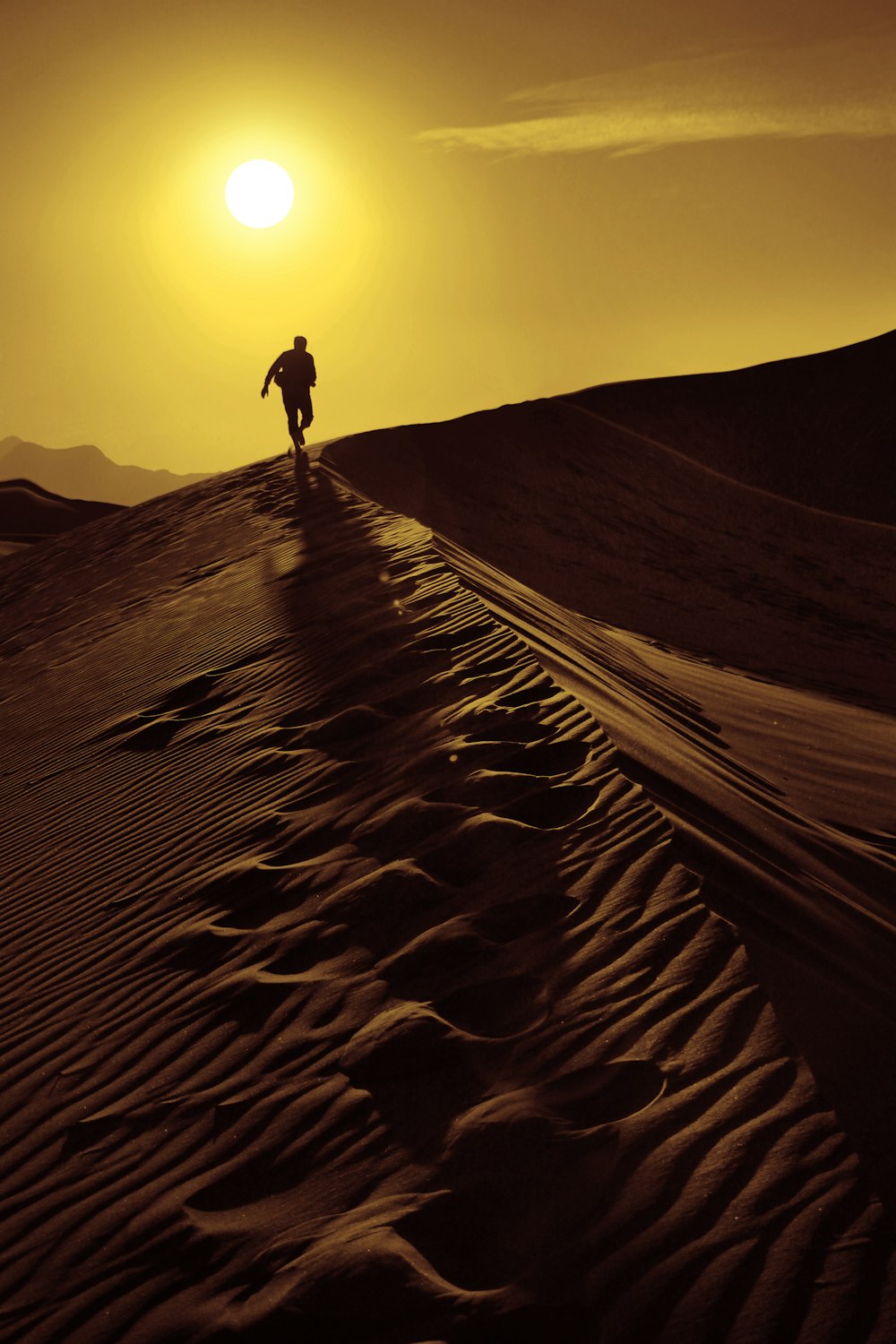 person walking on sand dunes