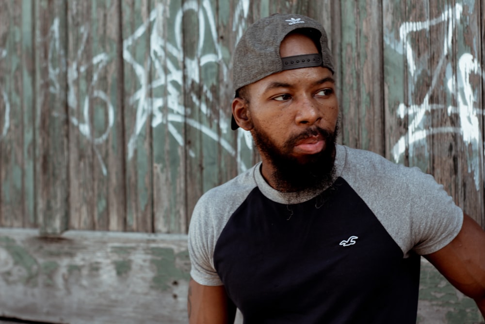 man in black and white crew neck t-shirt wearing gray cap