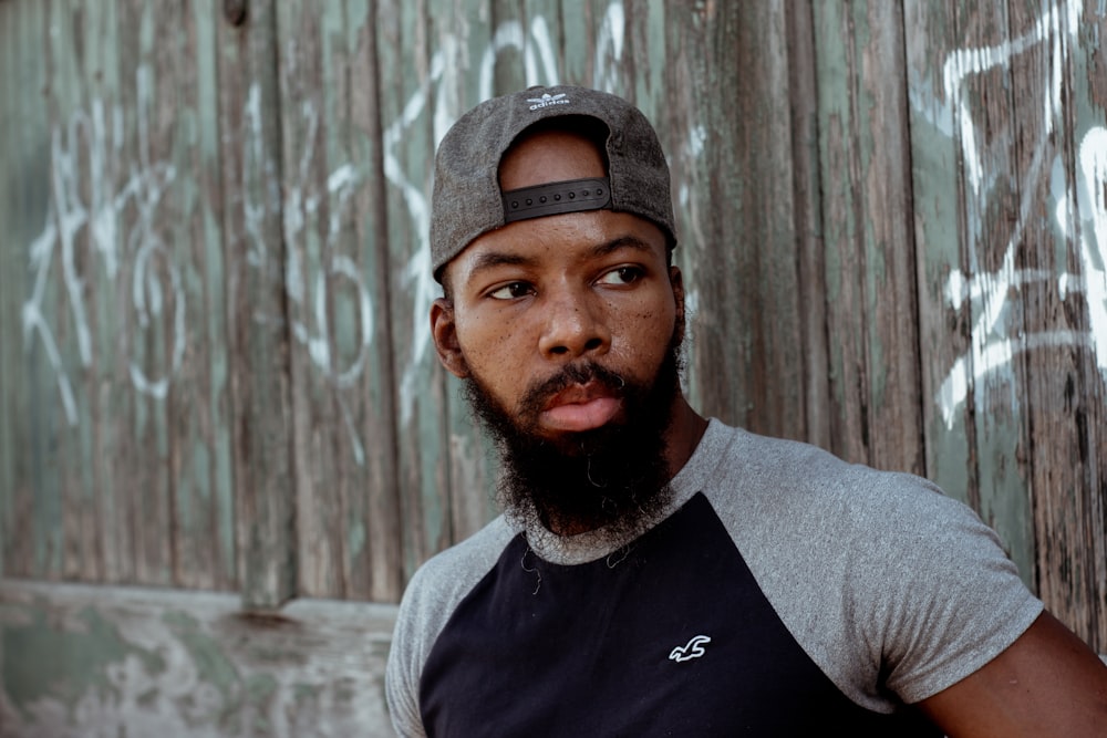 man in gray crew neck shirt wearing black fitted cap