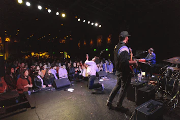 man in black jacket standing on stage