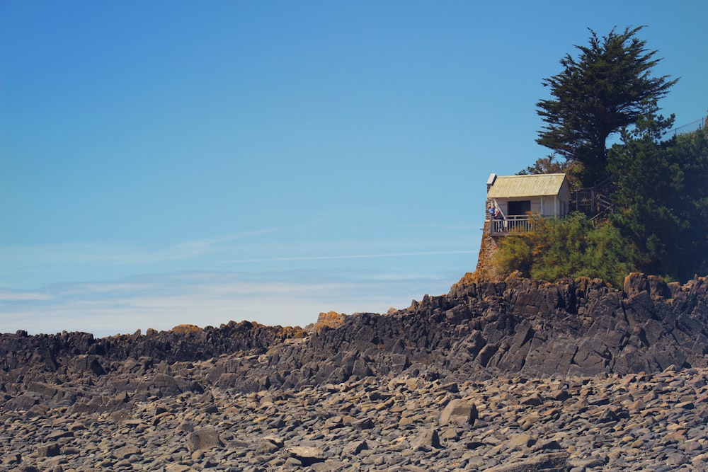 brown and white house on rocky hill under blue sky during daytime