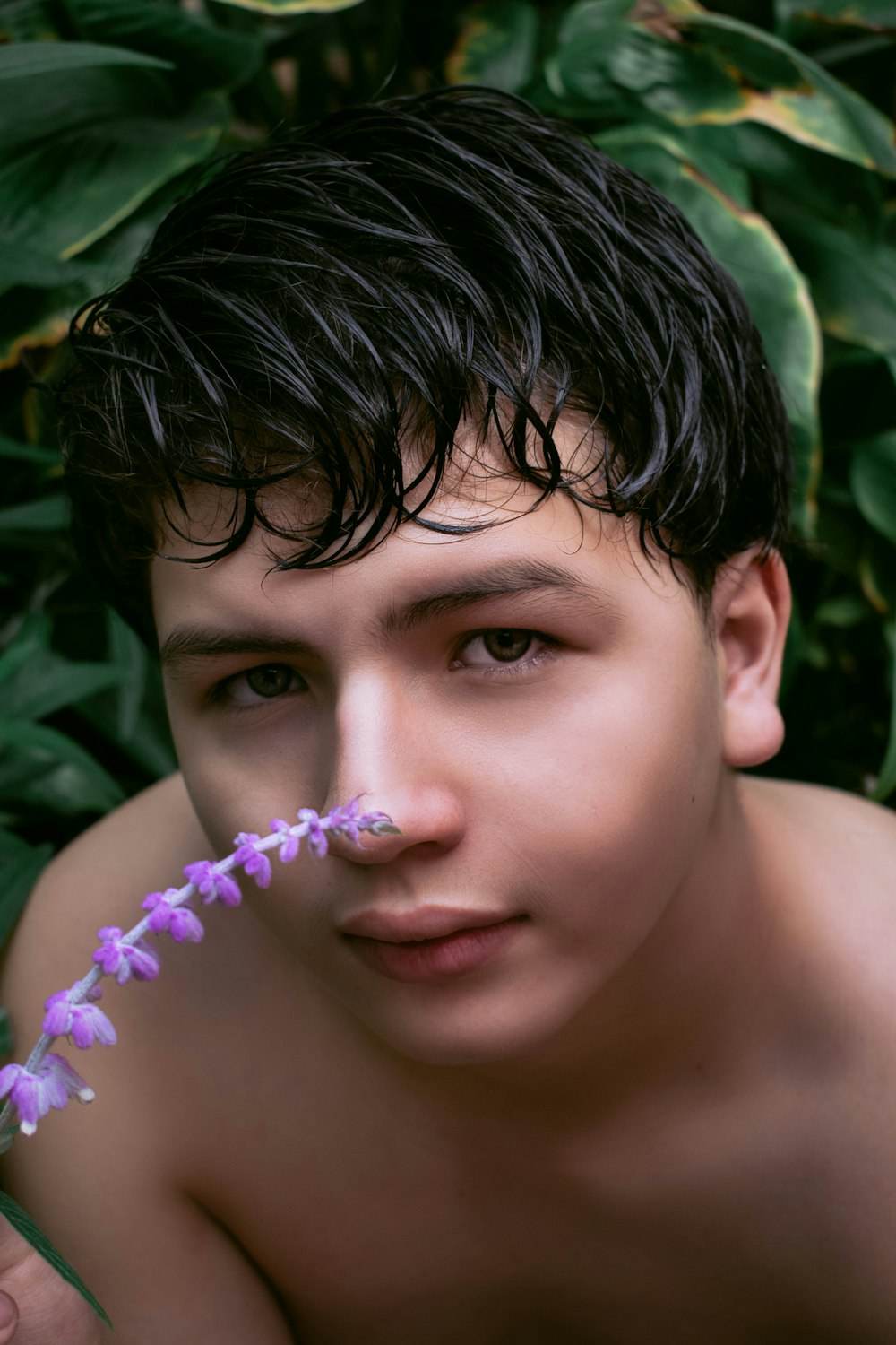 topless boy with purple flower on his ear