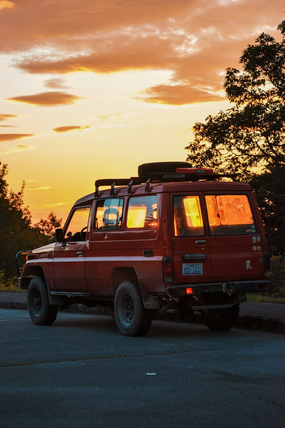 昼間の灰色のアスファルト道路を走る黒いSUV