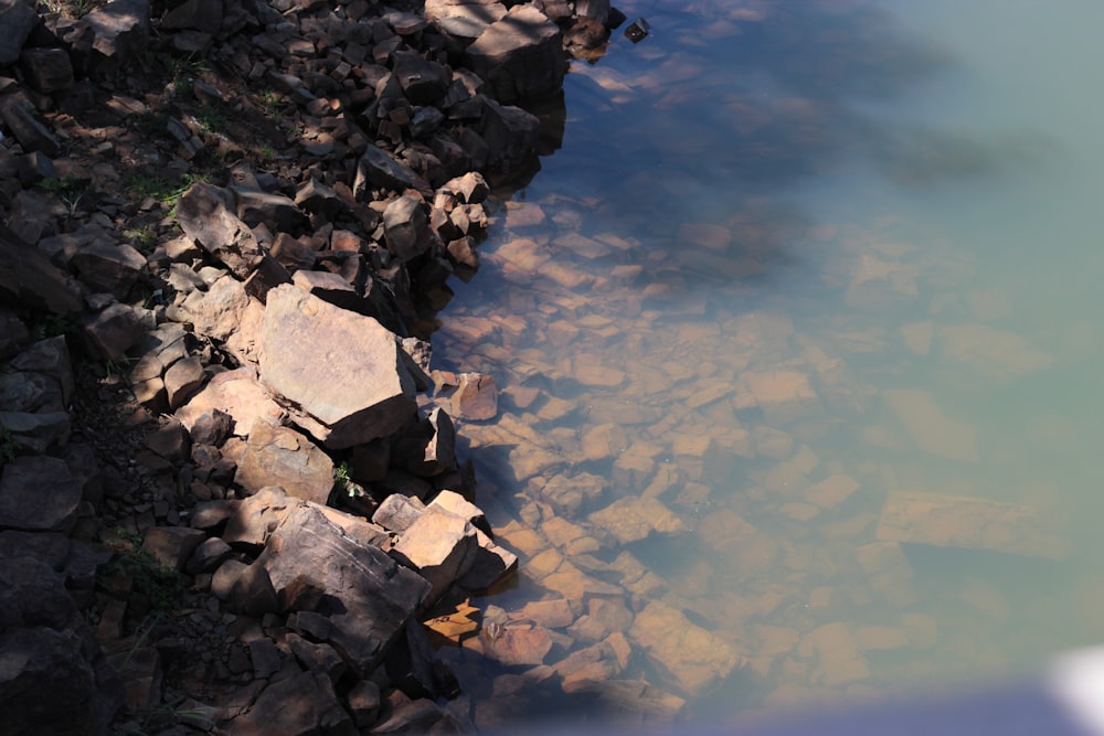 gray rocks on body of water during daytime