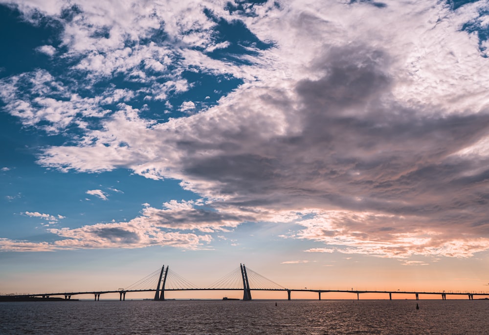 bridge under blue sky and white clouds during daytime