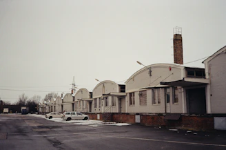 A row of sturdy labor hutments arranged neatly at a busy industrial site.