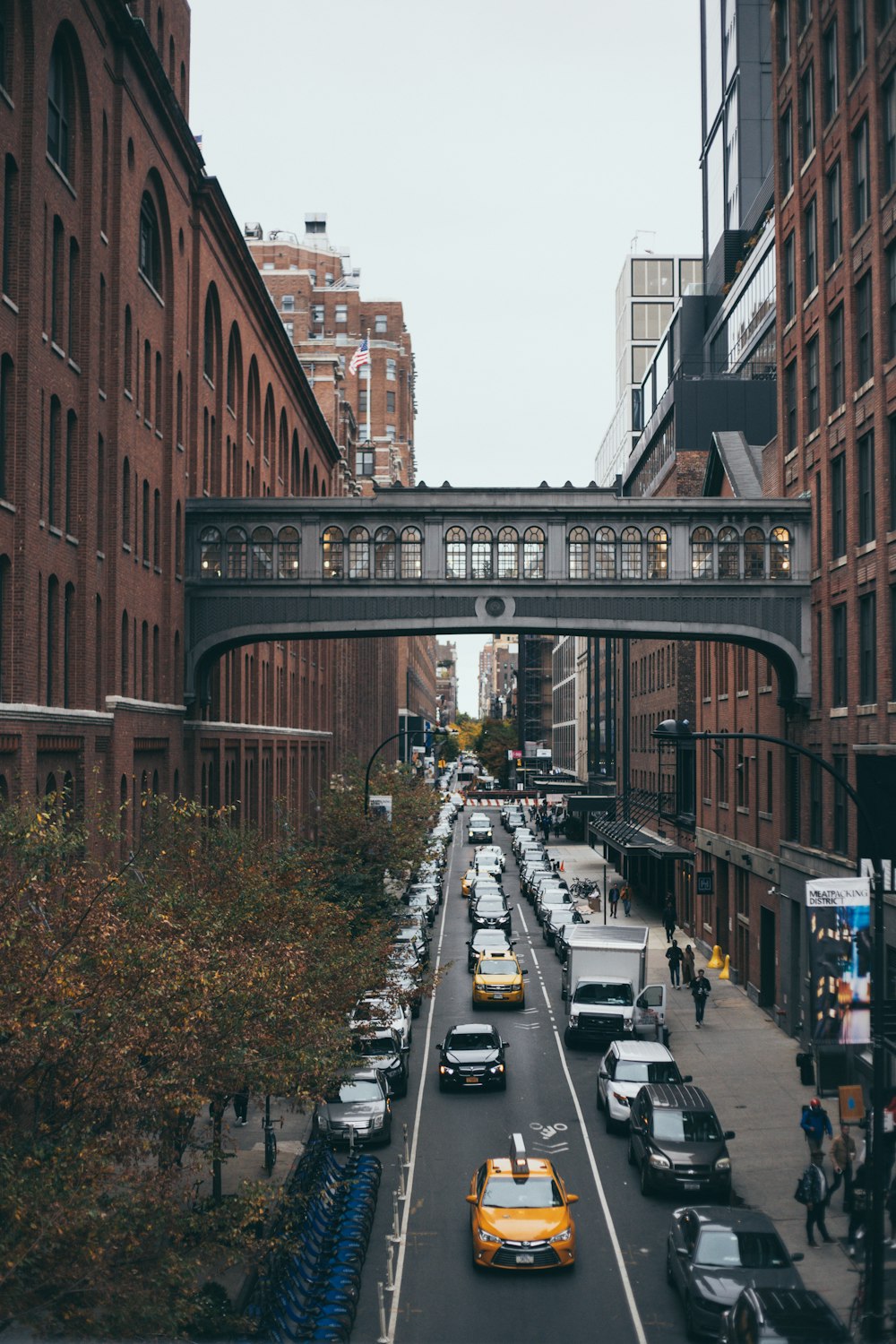 cars parked on the side of the road in between buildings during daytime