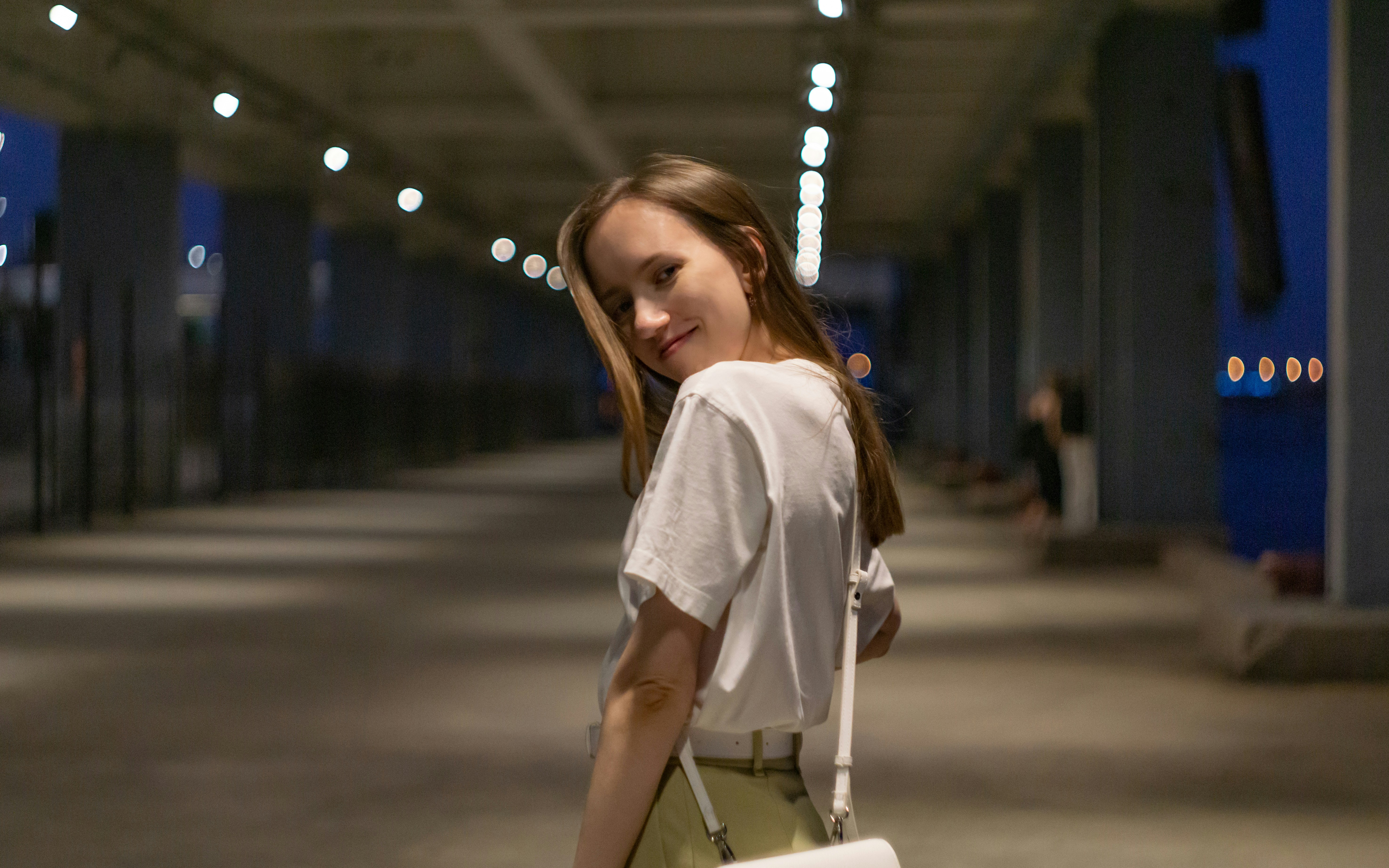 girl in white shirt standing on road during night time