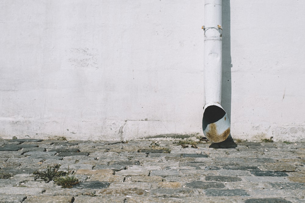 poteau en béton blanc près d’un mur blanc