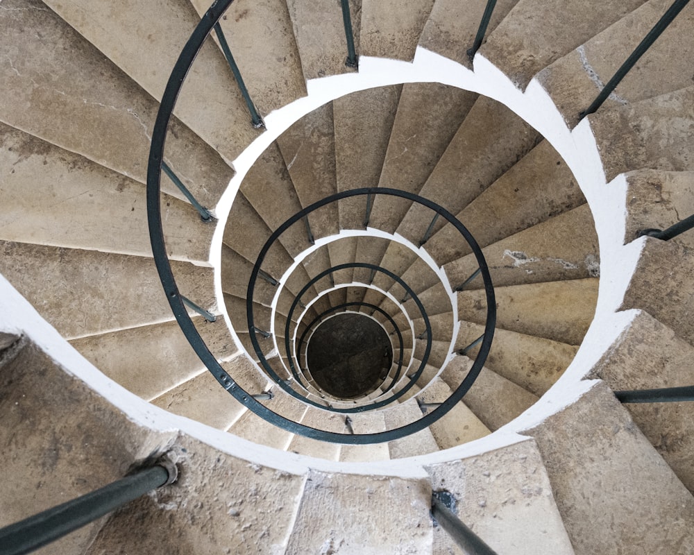 brown wooden spiral staircase with black metal railings