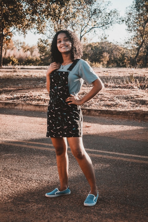 A model wearing a light summer dress in a sunny park.
