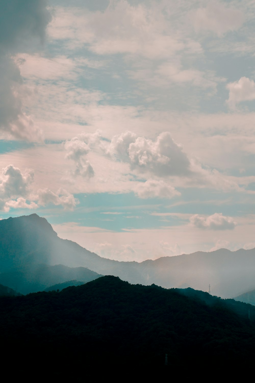 white clouds over mountain during daytime