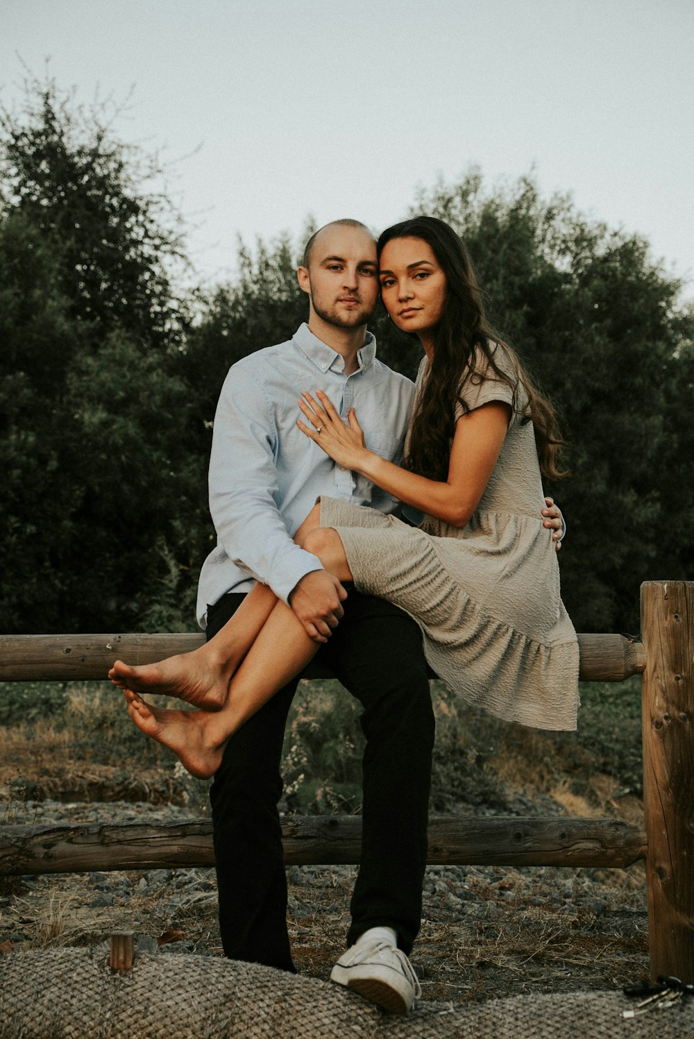 man in white dress shirt hugging woman in brown sleeveless dress