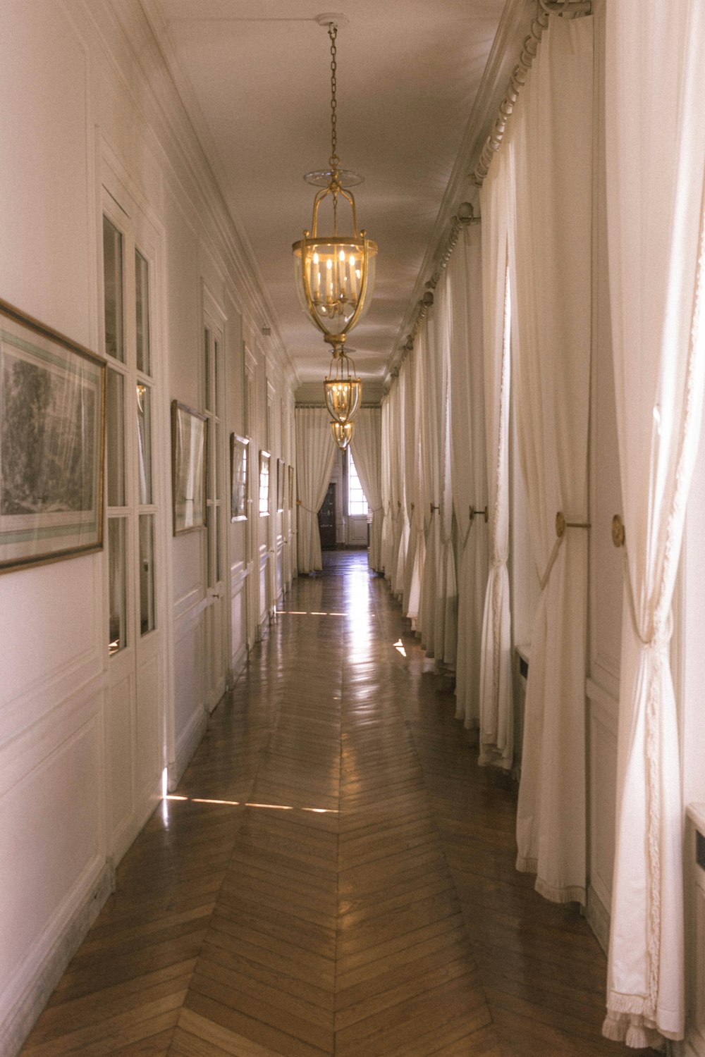 white and brown hallway with pendant lamps