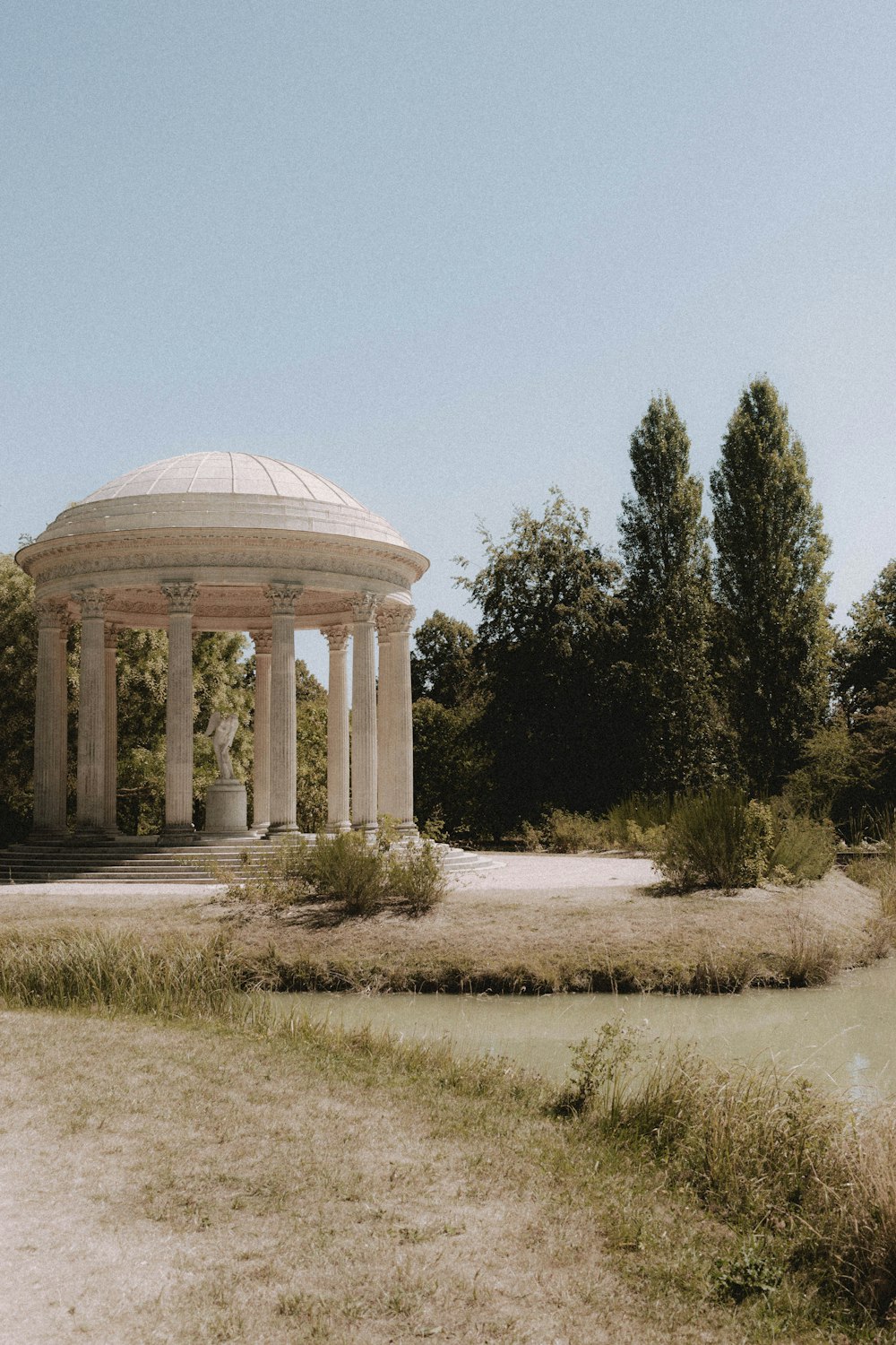 white dome building surrounded by green trees under blue sky during daytime