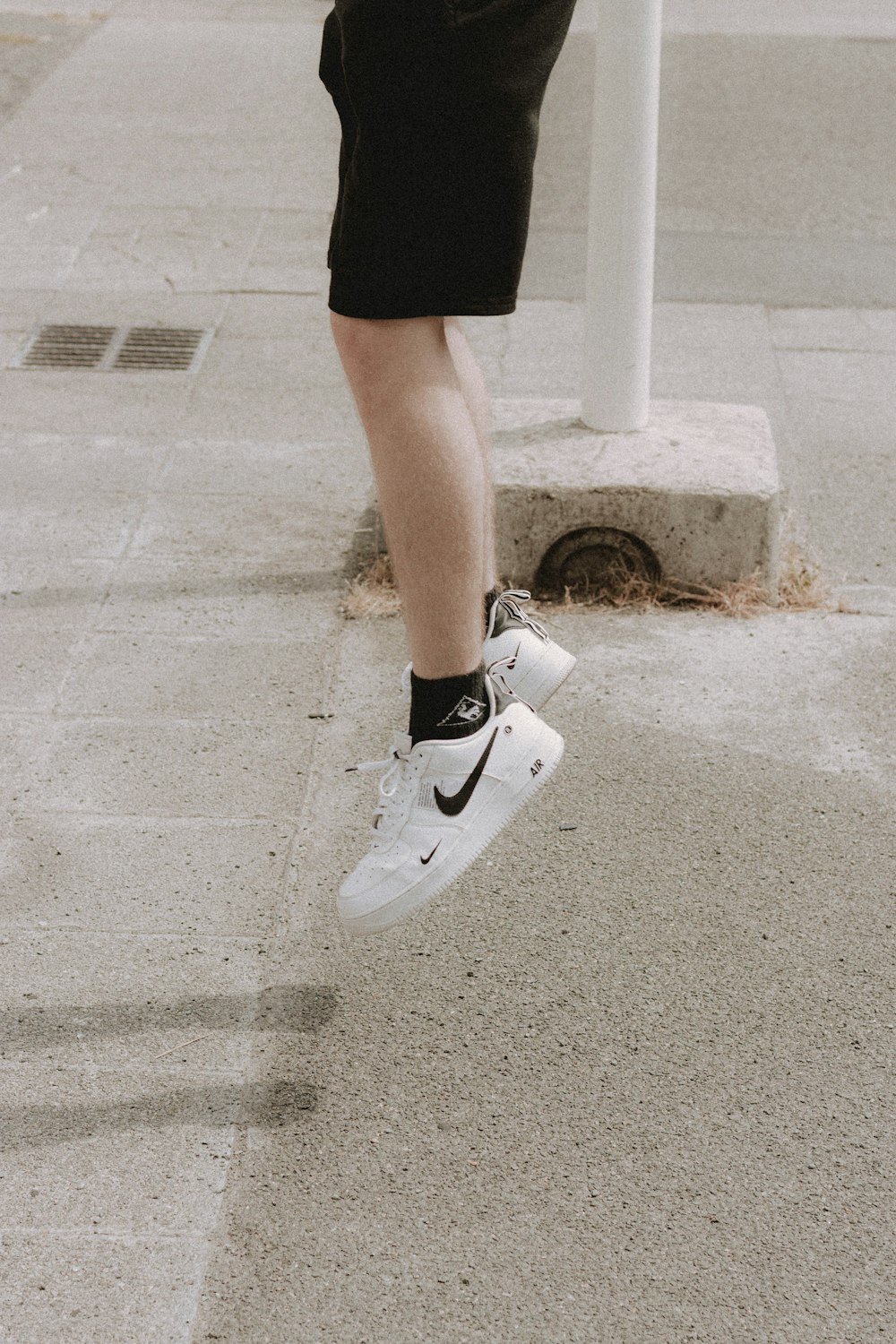 person in black shorts and white nike sneakers