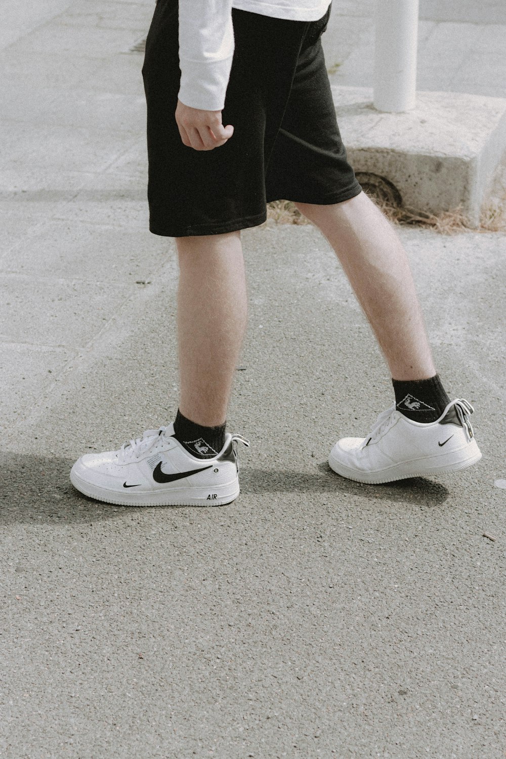 Foto persona con pantalones cortos negros y zapatillas nike blancas –  Imagen París gratis en Unsplash