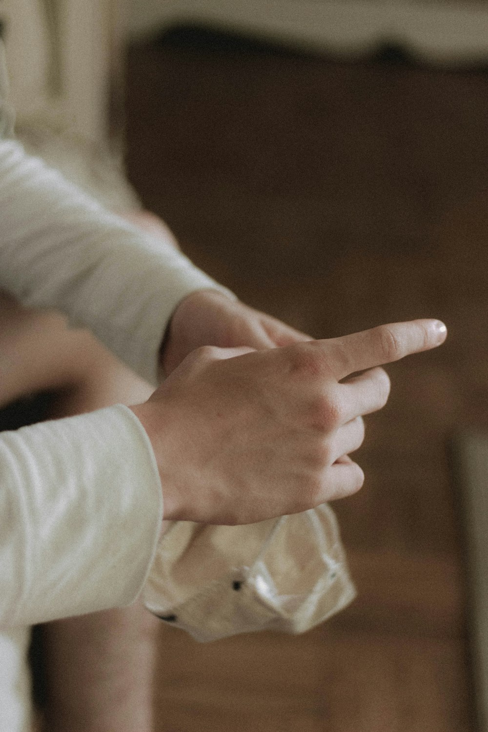 person in white long sleeve shirt holding hands