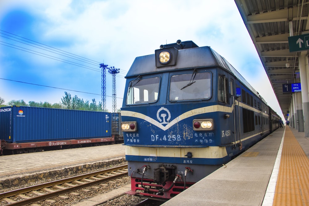 blue and red train on rail tracks during daytime