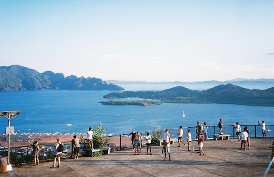 people standing on green grass field near body of water during daytime in Mt. Tapyas Philippines