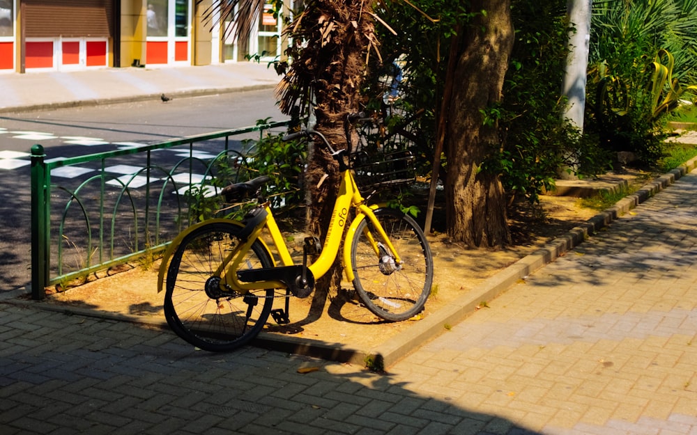 Vélo jaune et noir garé à côté d’un arbre