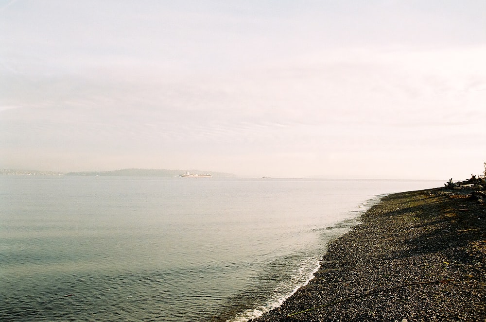 body of water under white sky during daytime