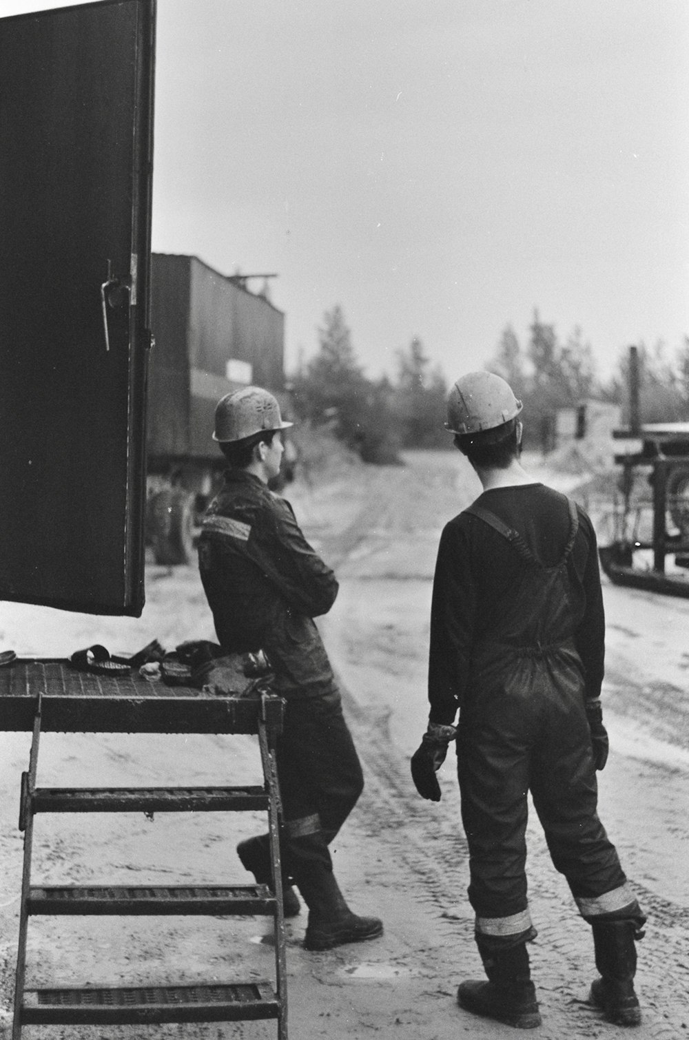 man in black jacket and white cap standing beside man in black jacket