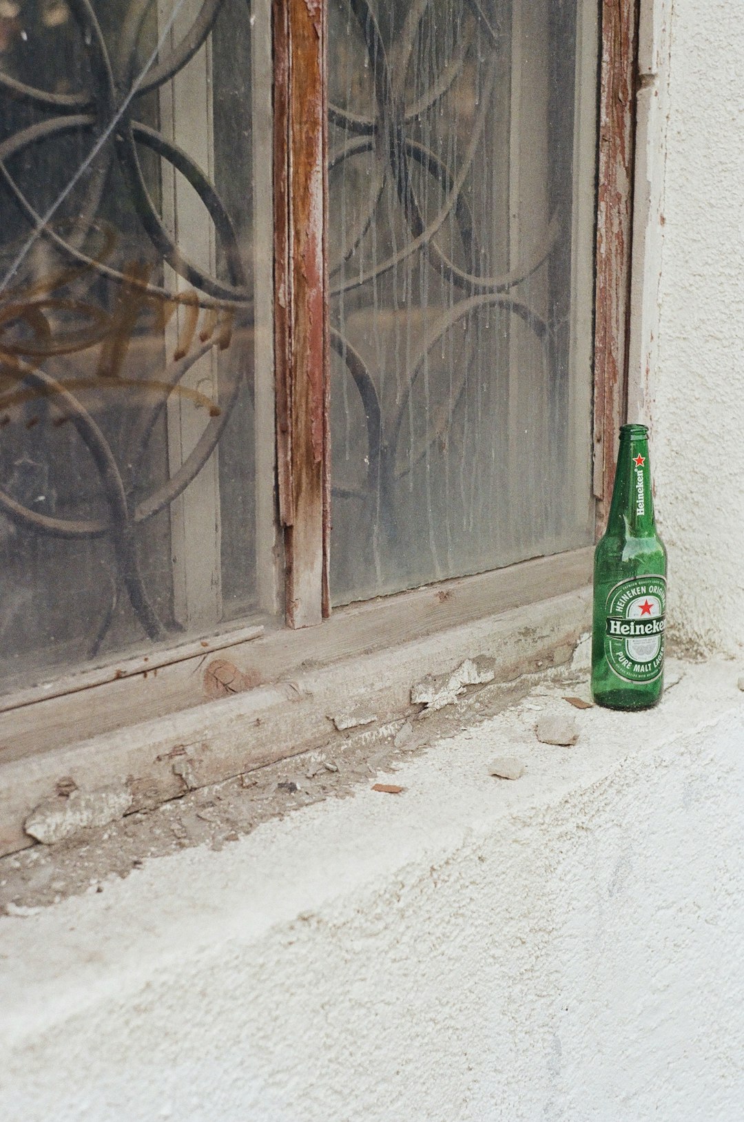 green glass bottle beside window