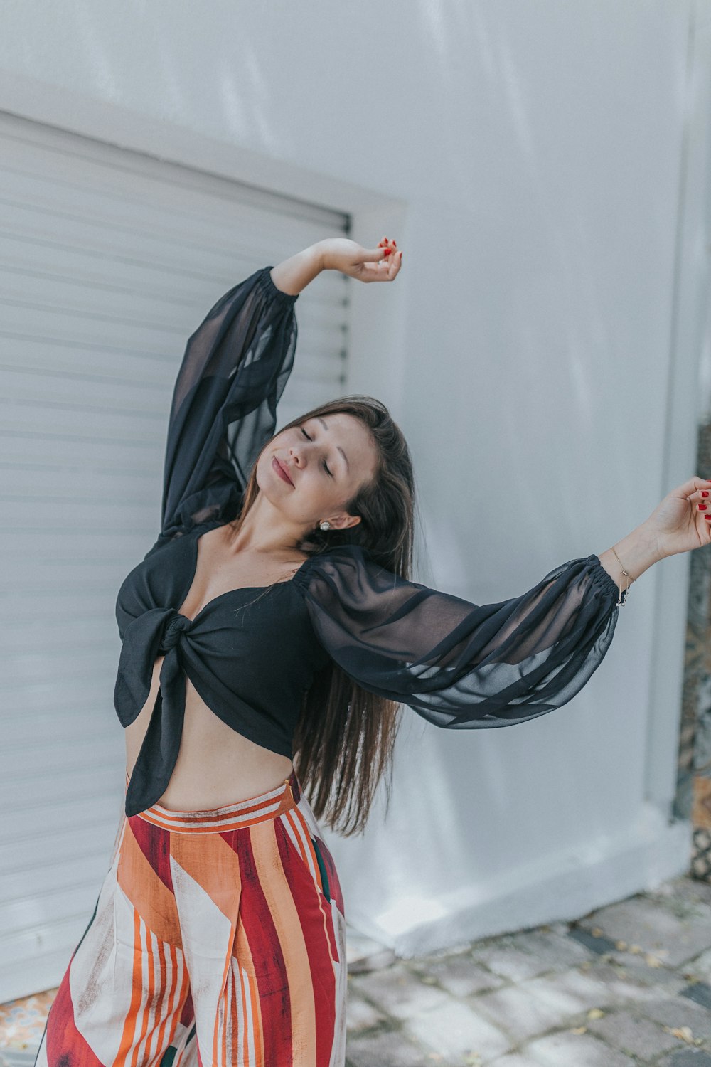 woman in black and orange dress standing near white wall