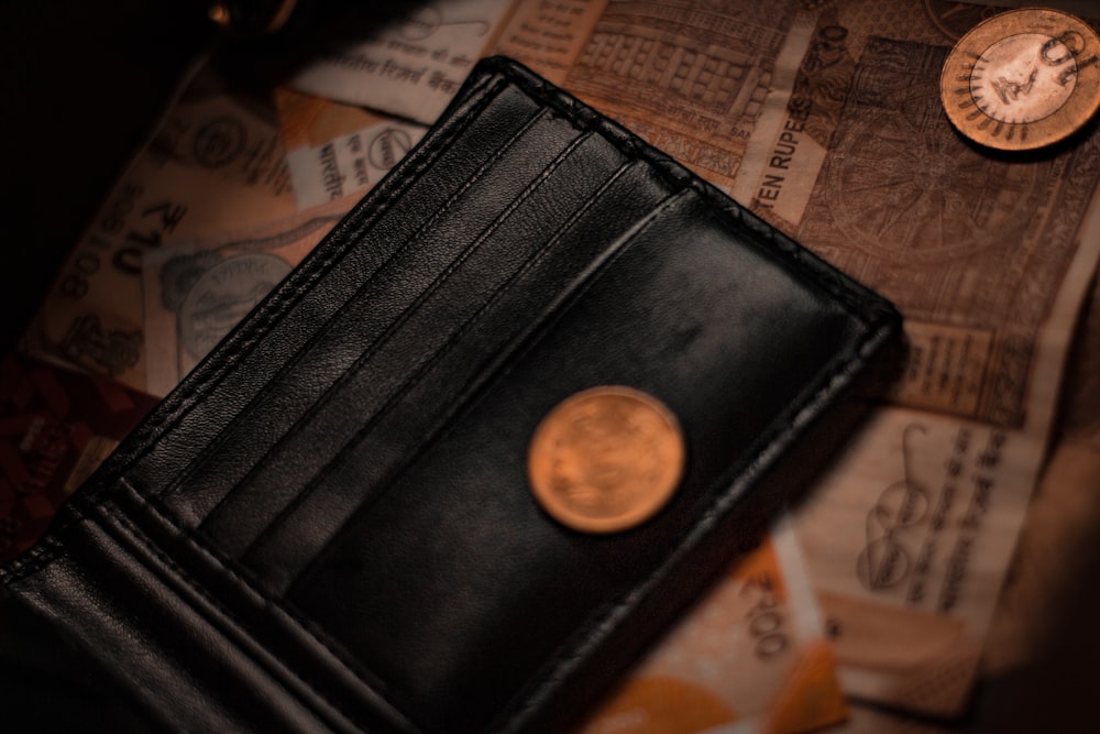 black leather wallet on white and brown textile