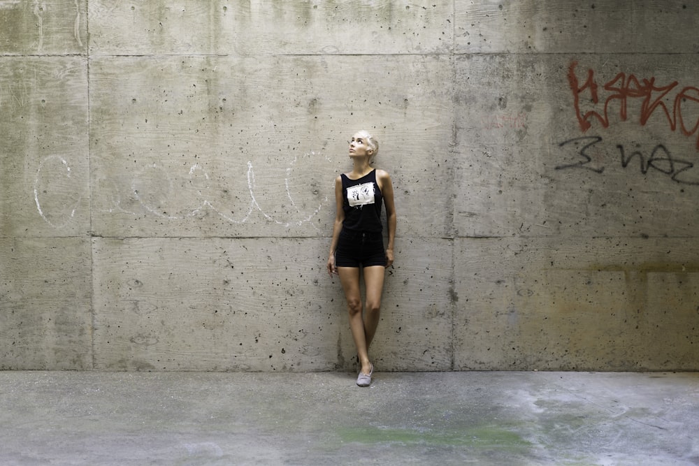 woman in black and white tank top standing on green floor