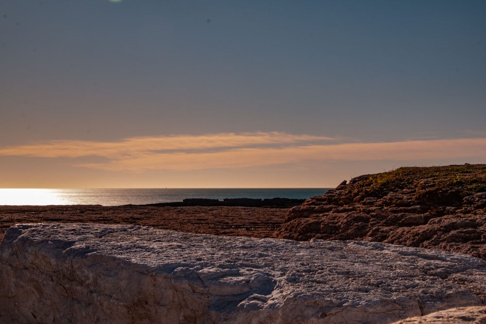 black rocky shore during sunset