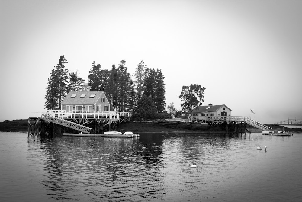 grayscale photo of house near body of water