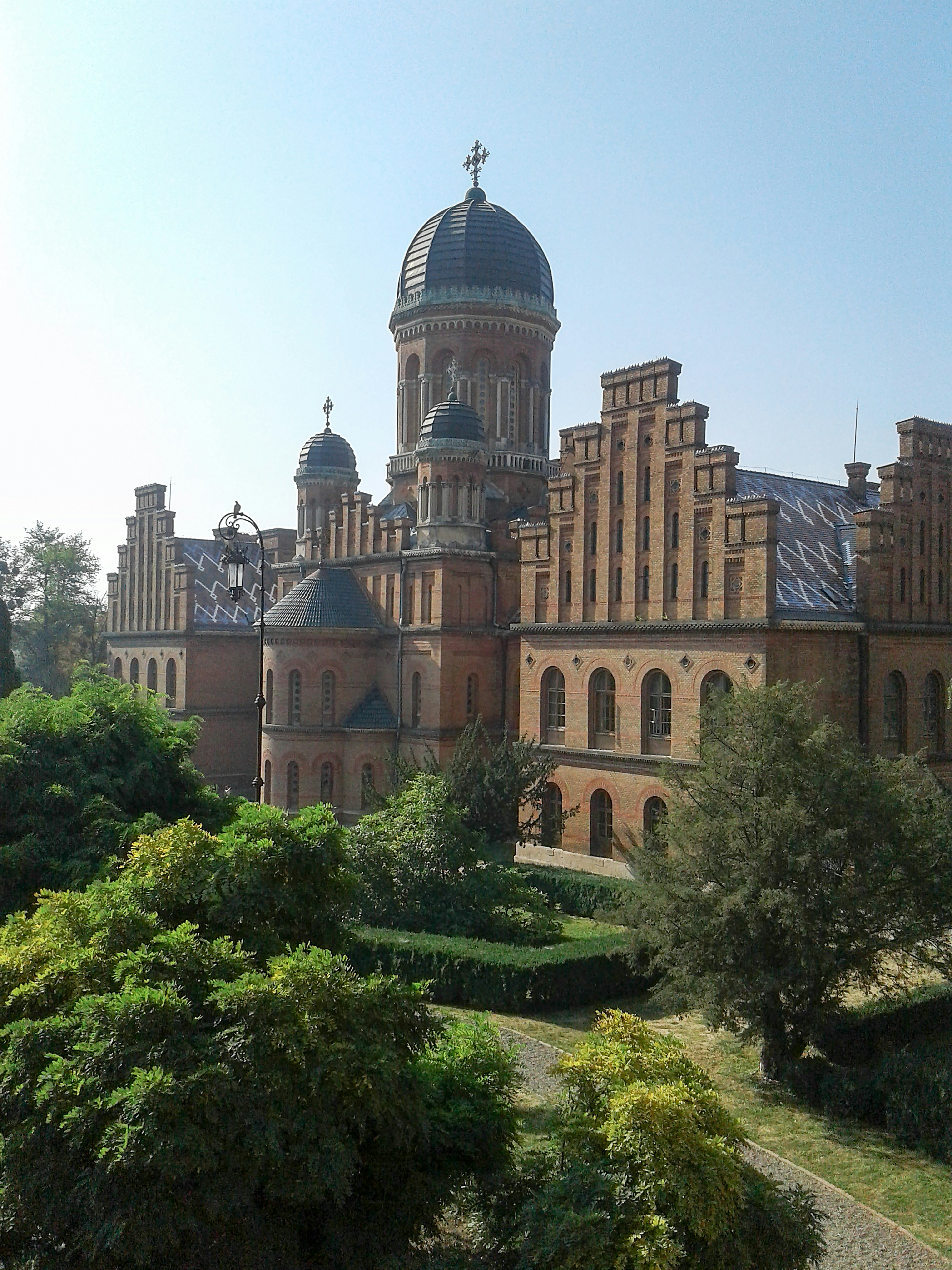 brown concrete building surrounded by green trees during daytime
