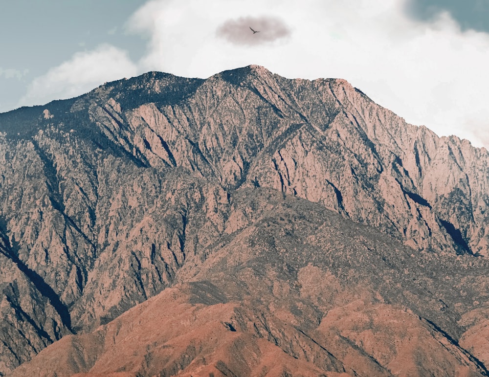 Montaña rocosa marrón bajo nubes blancas durante el día