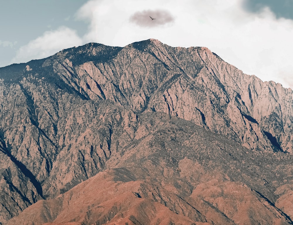 brown rocky mountain under white clouds during daytime