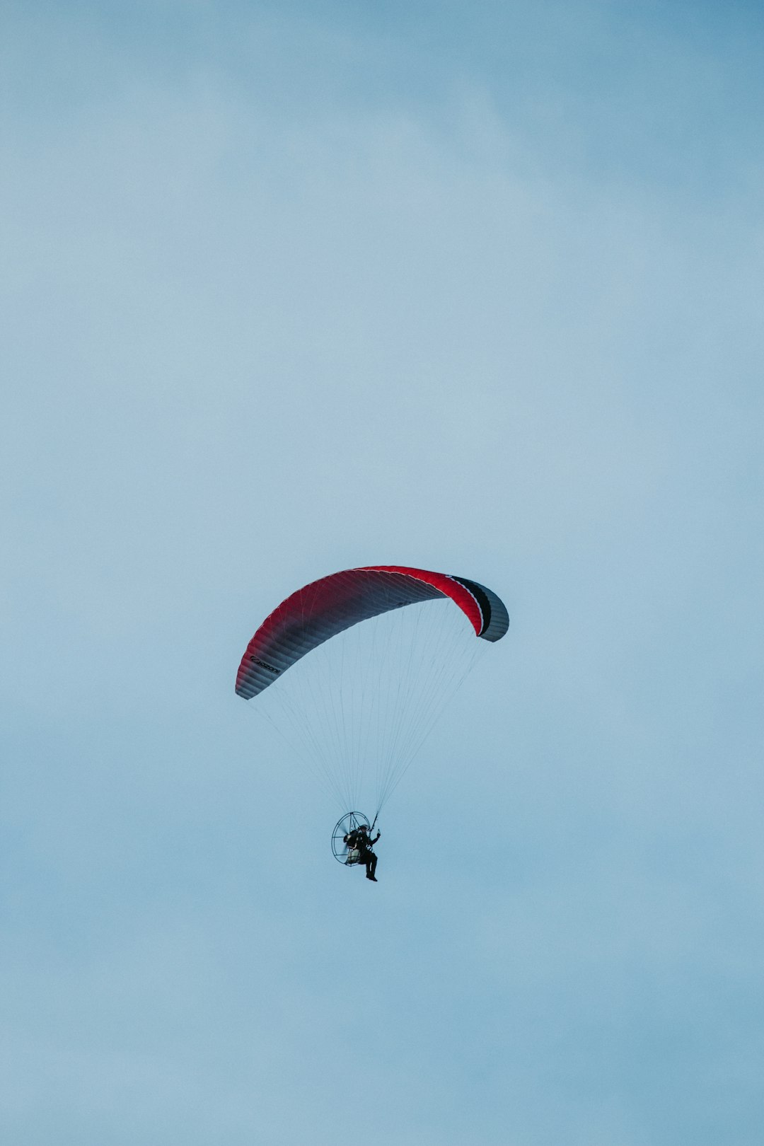 person in red parachute under white sky during daytime