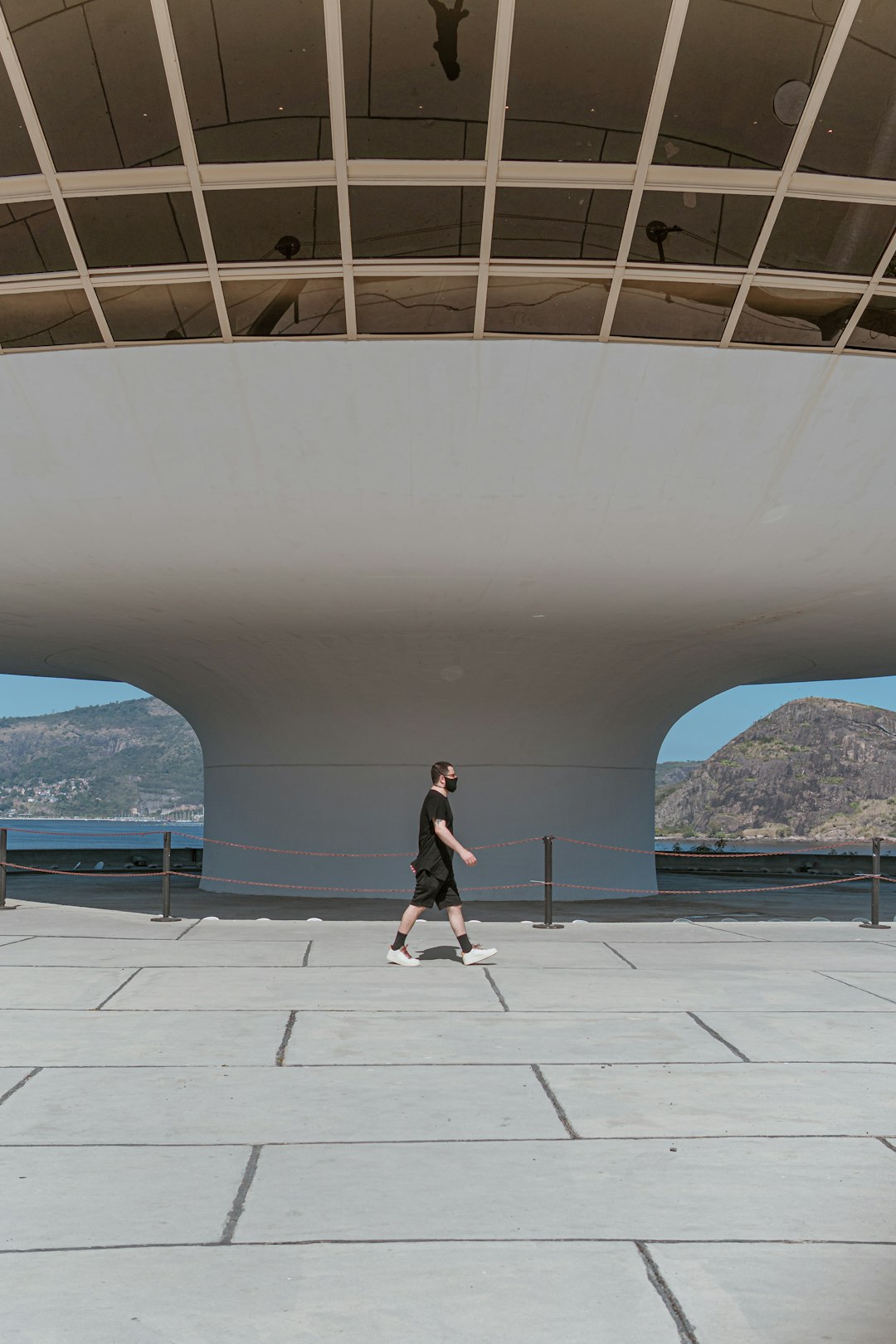 woman in black shirt and black pants standing on white concrete floor near swimming pool during