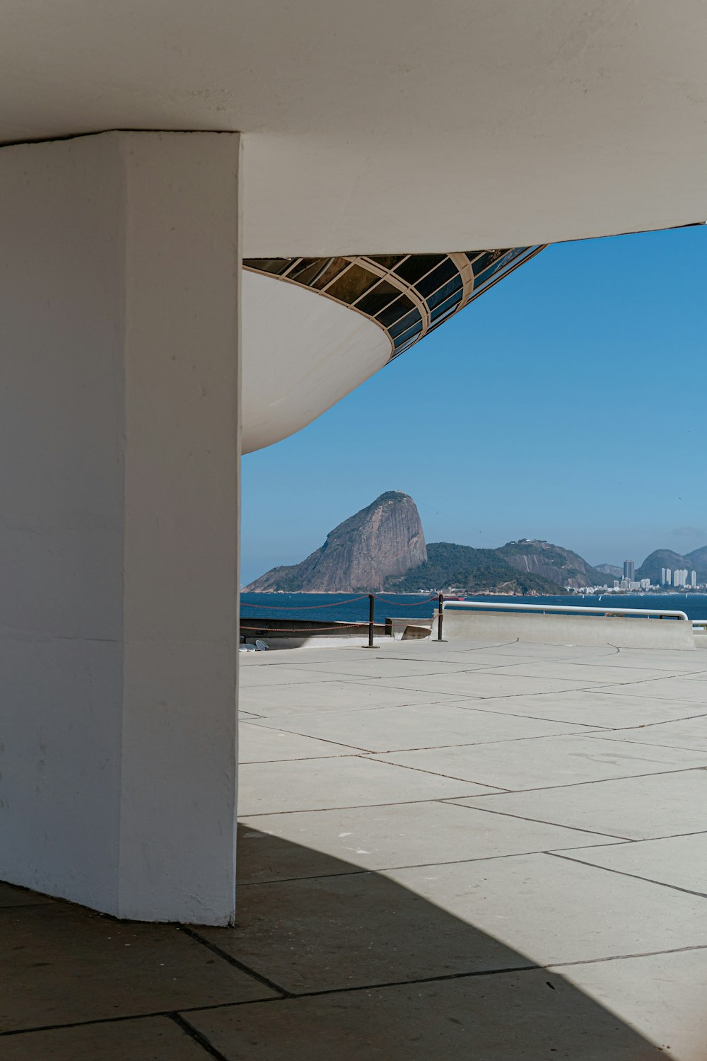 Bâtiment en béton blanc près de la mer bleue sous le ciel bleu pendant la journée