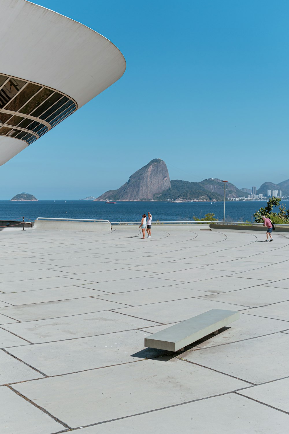 people walking on white concrete floor near sea during daytime